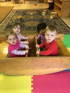 A group of young children in a wooden boat.