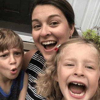 A woman and two children are smiling for the camera.