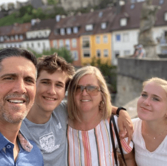 A family posing for the camera in front of some buildings.