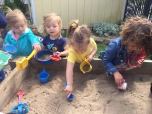 A group of children playing in the sand.