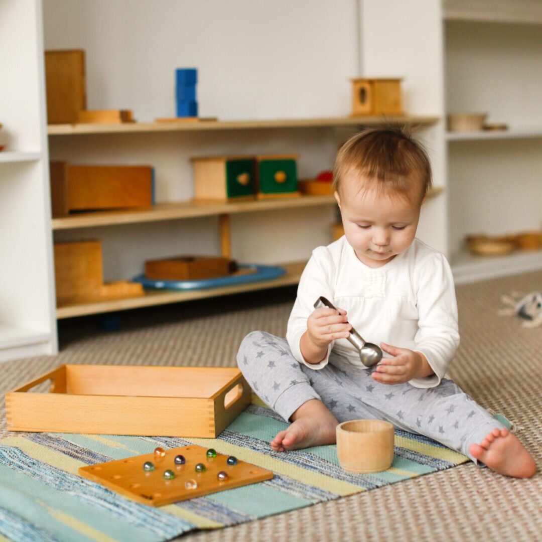 A baby playing with toys on the floor.